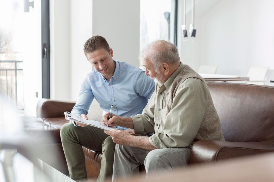 Elderly man and adult son signing documents for estate planning lawyers in Mcallen Texas