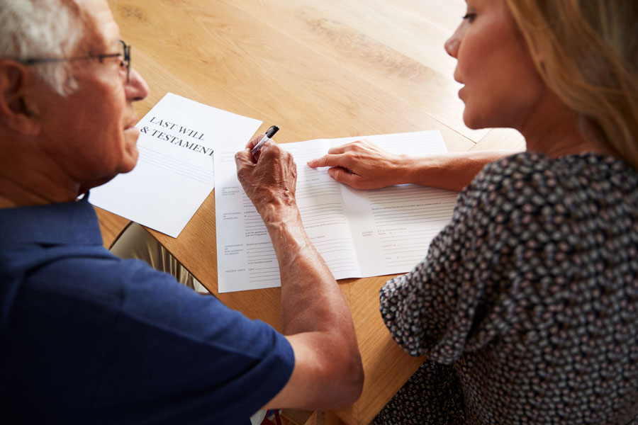 young woman and elderly man signing papers for a probate attorney McAllen texas.