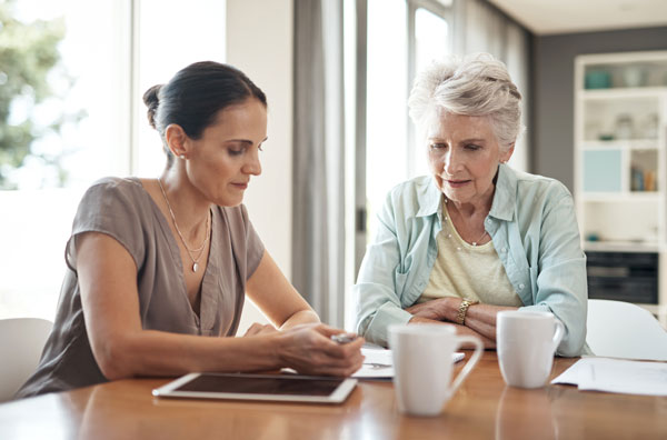 young estate planning lawyer on McAllen assisting her elderly mother with her finances